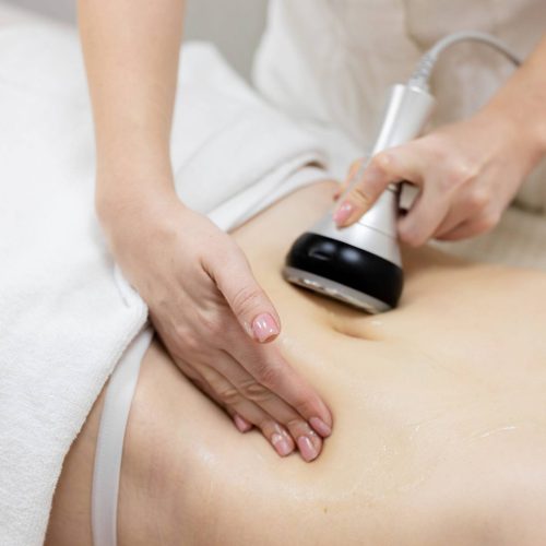 RF body cavitation lifting procedure in a beauty salon. Ultrasound therapy to reduce fat and elasticity of the skin. Cosmetic ultrasonic anti-cellulite massage close-up