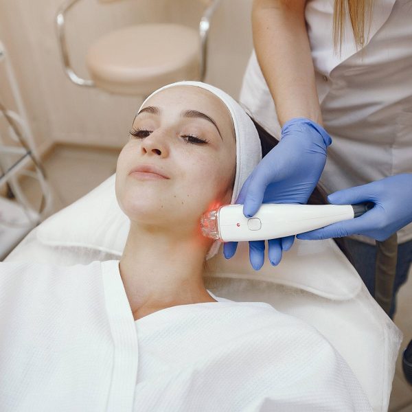 Cosmetologist use laser. Woman with cosmetologist. Lady in a beauty studio.