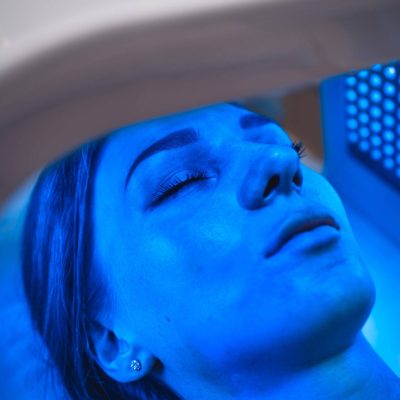 A young woman takes care of her skin with an LED mask in a beauty salon. High quality 4k footage