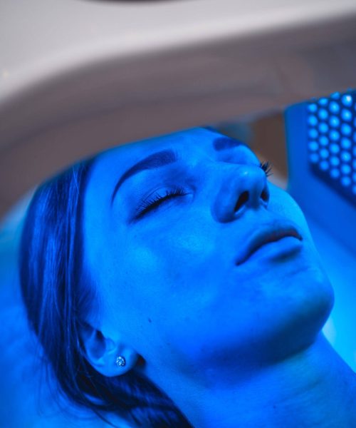 A young woman takes care of her skin with an LED mask in a beauty salon. High quality 4k footage